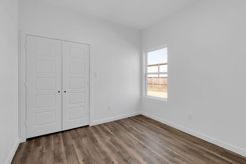 104 Runnels Street Willis, TX 77378 - Photo 15 of 27 a view of an empty room with wooden floor and a window