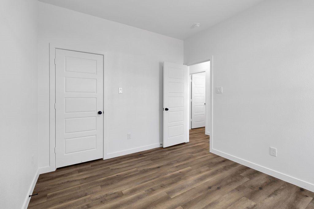 104 Runnels Street Willis, TX 77378 - Photo 18 of 27 a view of an empty room with wooden floor