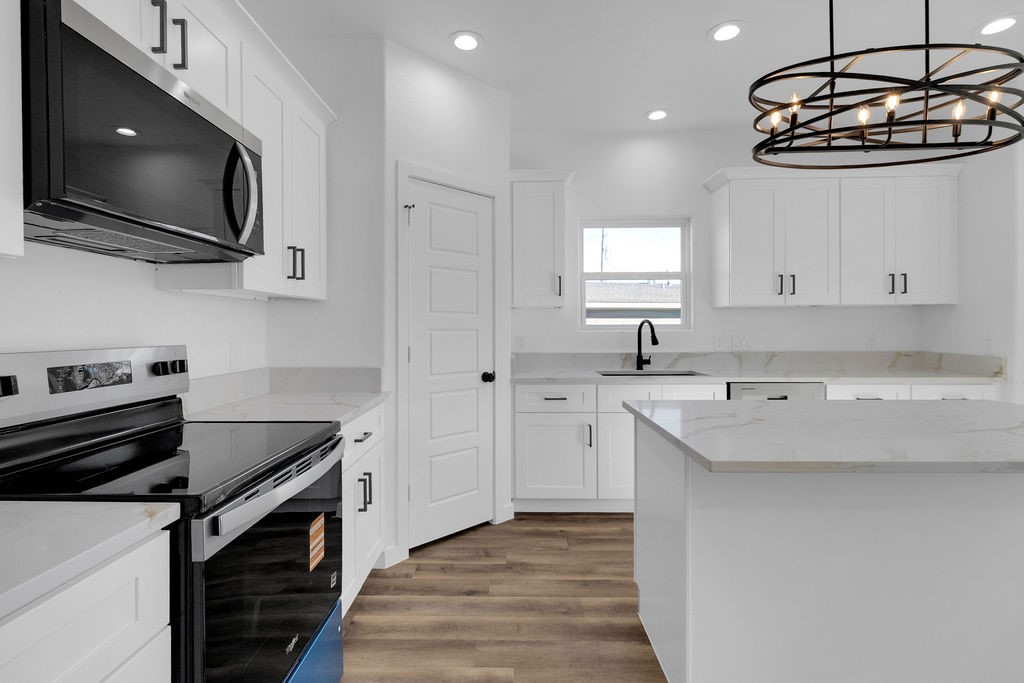 104 Runnels Street Willis, TX 77378 - Photo 7 of 27 a kitchen with stainless steel appliances a stove microwave and sink