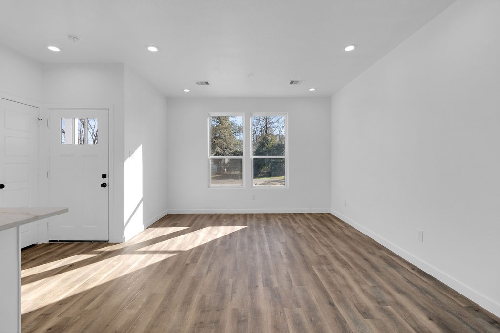 104 Runnels Street Willis, TX 77378 - Photo 10 of 27 a view of an empty room with wooden floor and a window