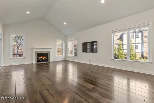 an empty room with windows and fireplace