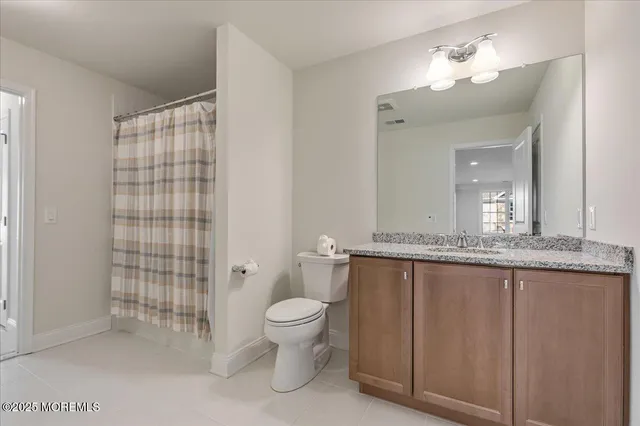 a bathroom with a granite countertop sink a toilet a mirror and shower