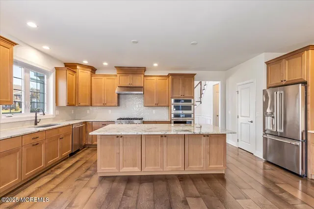 a kitchen with stainless steel appliances granite countertop a refrigerator and a stove top oven