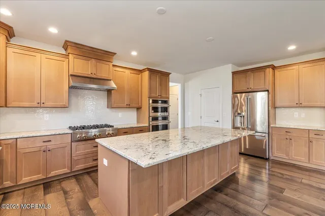 a kitchen with stainless steel appliances granite countertop a sink stove and refrigerator
