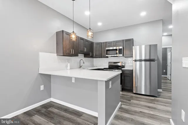 a kitchen with kitchen island a sink stainless steel appliances and cabinets