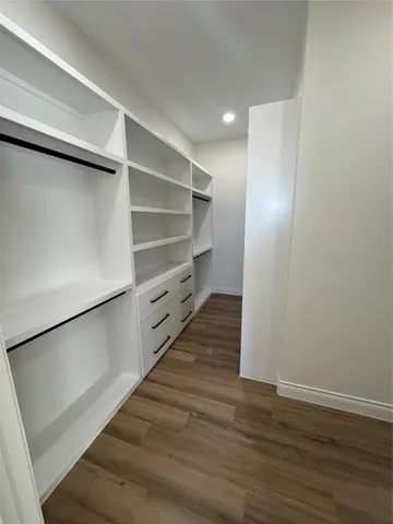 a room with walk in closet and wooden floor