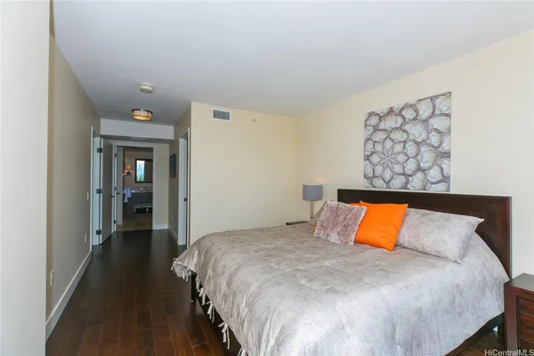 a view of a hallway with wooden floor and a livingroom with furniture