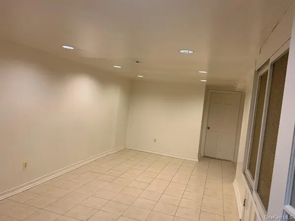 an empty room with white walls and tiles