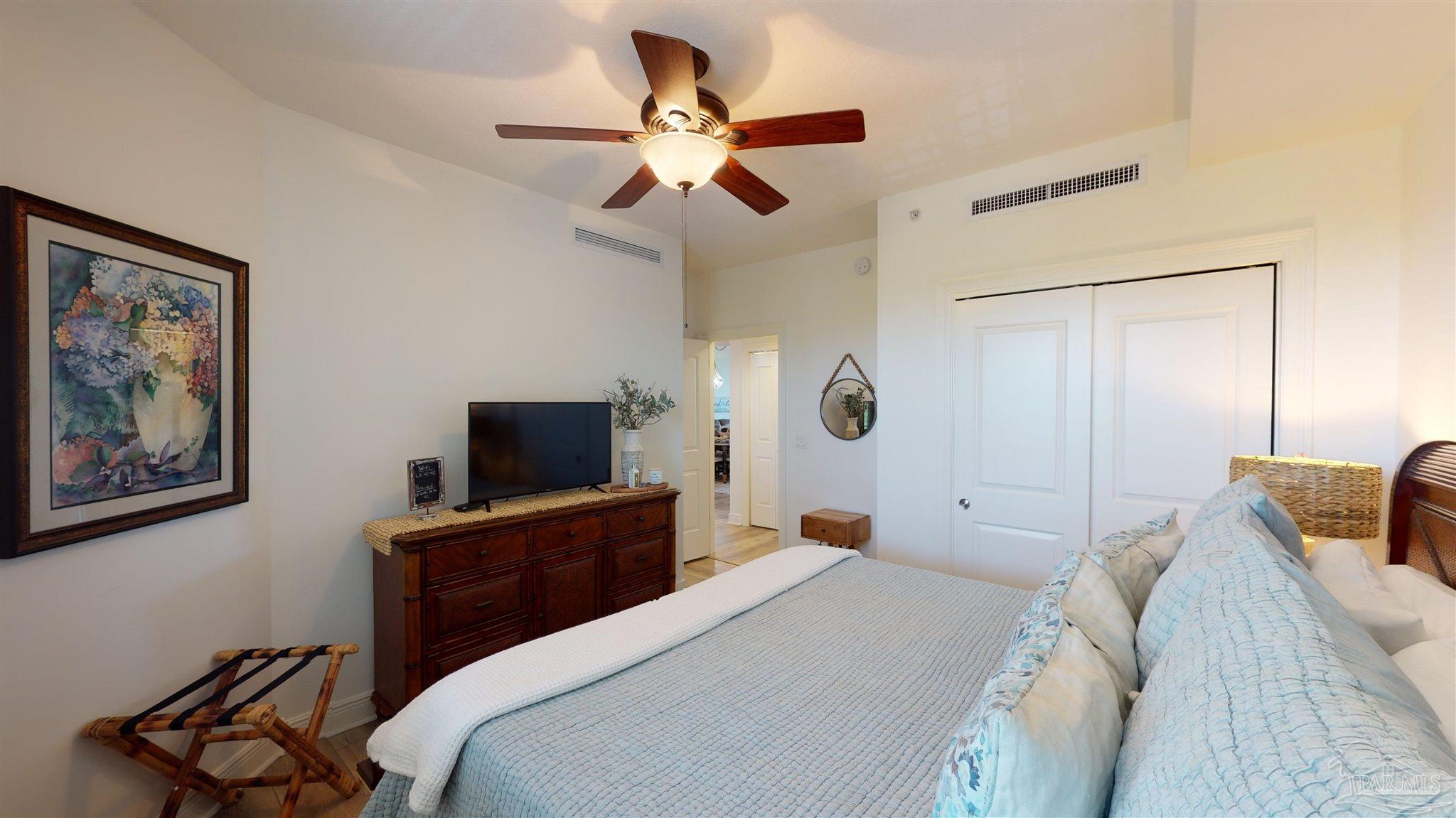 608 Lost Key Drive, Unit 404C Perdido Key, FL 32507 - Photo 12 of 28 a bedroom with a large bed a flat screen tv and a chandelier