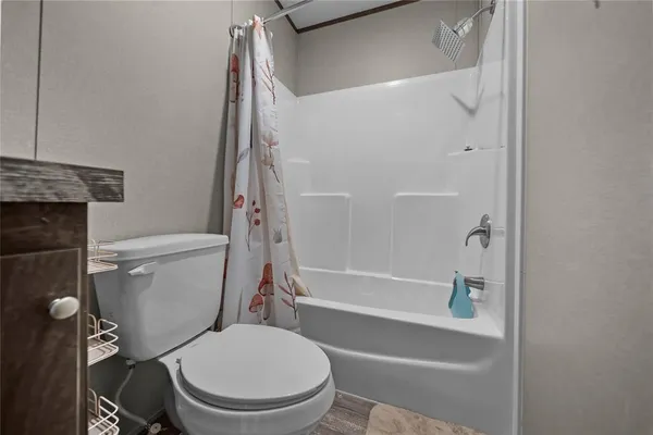 a white toilet sitting next to a bath tub