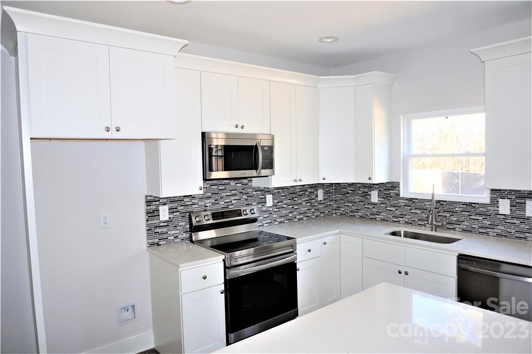 1048 McLain Road Kannapolis, NC 28083 - Photo 11 of 31 a kitchen with white cabinets and appliances