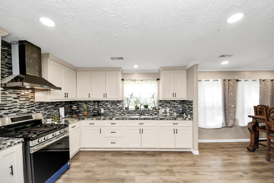 11844 Padok Road Houston, TX 77044 - Photo 19 of 41 a kitchen with stainless steel appliances kitchen island granite countertop a stove and a sink