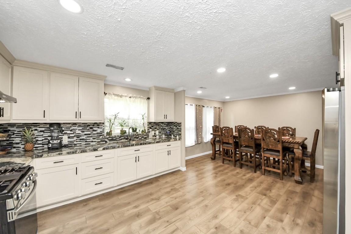 11844 Padok Road Houston, TX 77044 - Photo 20 of 41 a kitchen with stainless steel appliances kitchen island granite countertop a stove and white cabinets