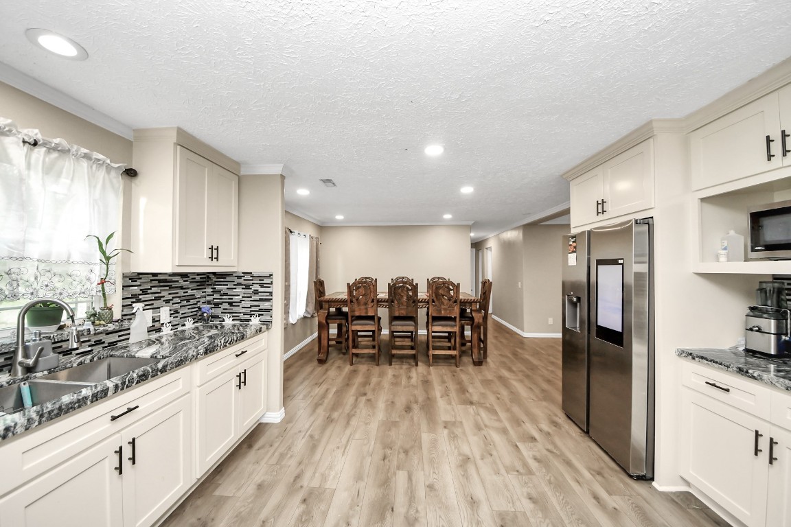11844 Padok Road Houston, TX 77044 - Photo 21 of 41 a large kitchen with stainless steel appliances a large counter top a stove a sink and a refrigerator