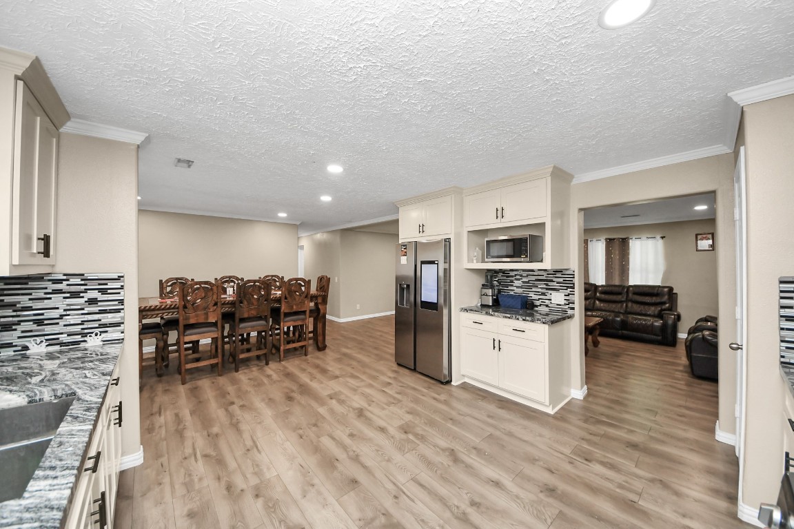 11844 Padok Road Houston, TX 77044 - Photo 22 of 41 a kitchen with stainless steel appliances a stove a sink dishwasher and a refrigerator with wooden floor