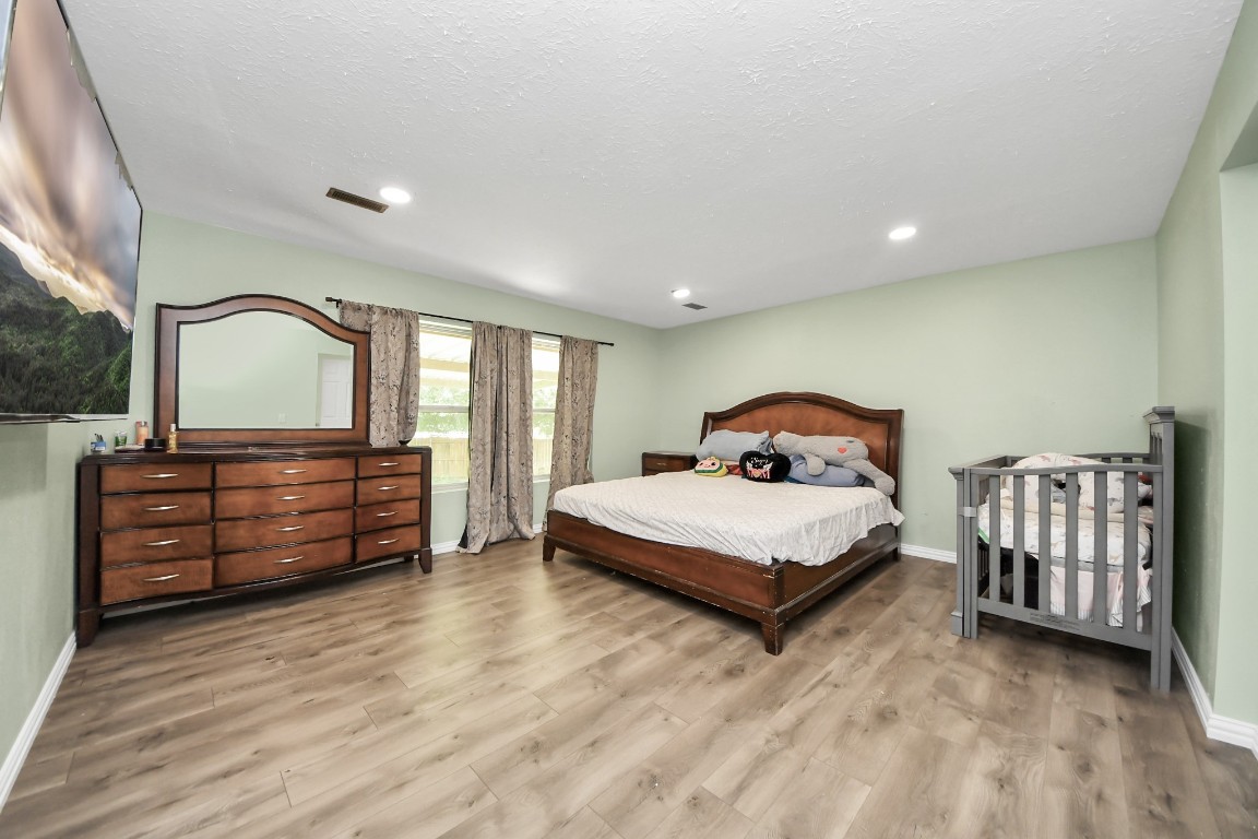 11844 Padok Road Houston, TX 77044 - Photo 24 of 41 a bedroom with a bed and a dresser with mirror