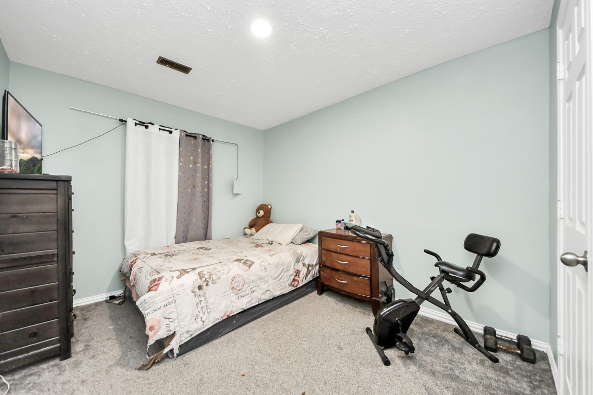 11844 Padok Road Houston, TX 77044 - Photo 35 of 41 a bedroom with a bed and a cabinet