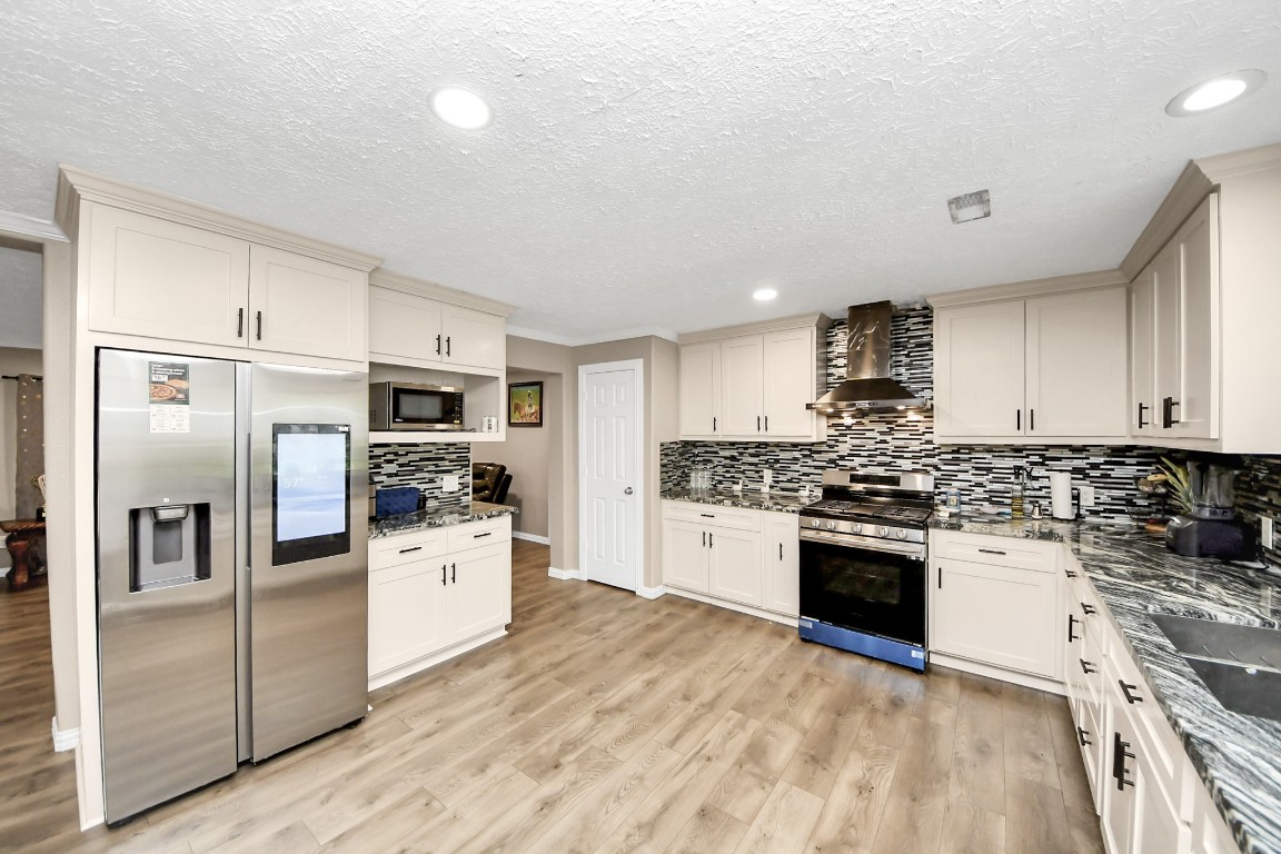 11844 Padok Road Houston, TX 77044 - Photo 5 of 41 a kitchen with stainless steel appliances granite countertop a stove top oven a refrigerator a sink and dishwasher