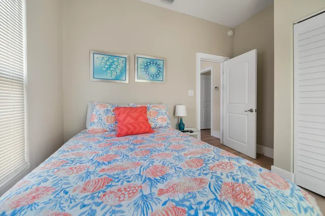 a bedroom with a bed and a lamp on dresser