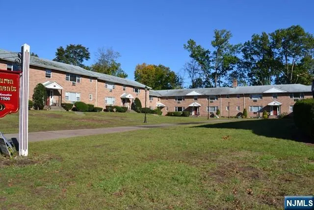 a view of a white house with a big yard and potted plants