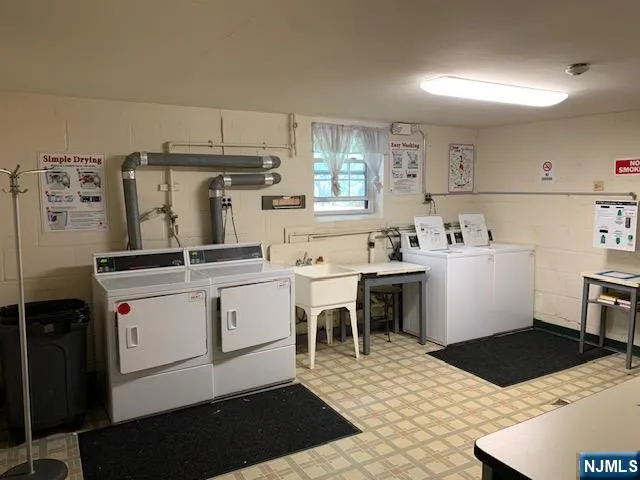 a kitchen with a sink a stove a refrigerator and white cabinets