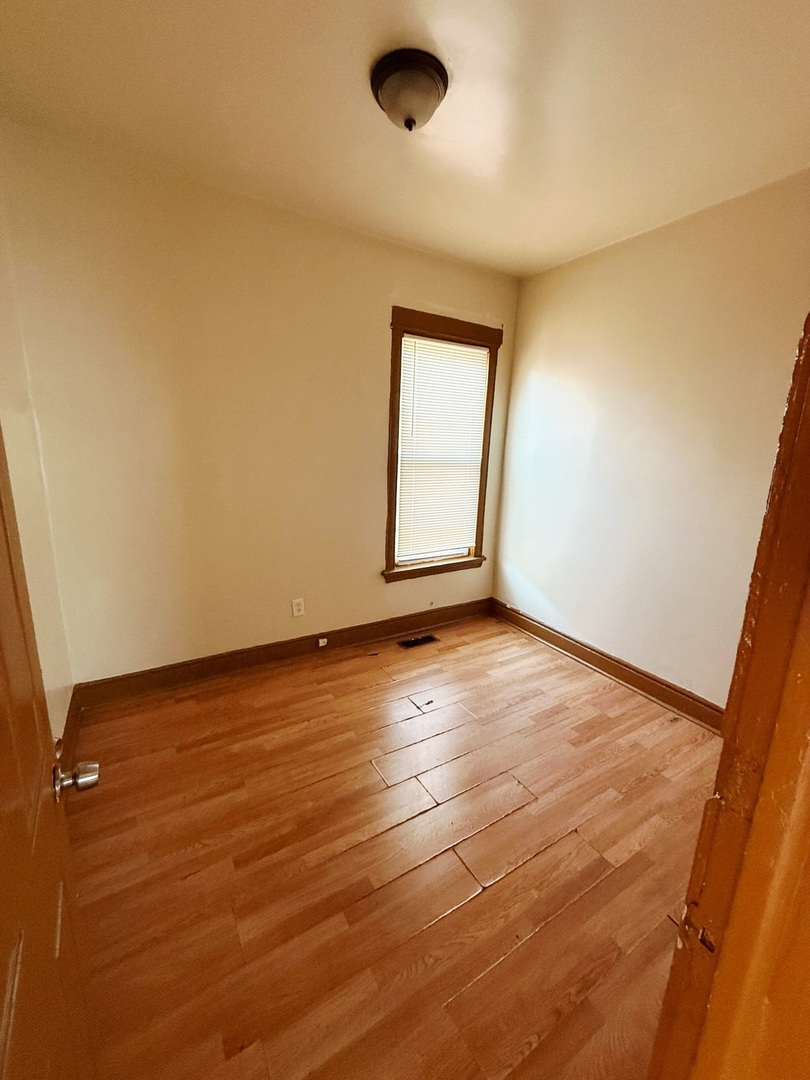 6643 South Laflin Street Chicago, IL 60636 - Photo 4 of 15 an empty room with wooden floor and windows