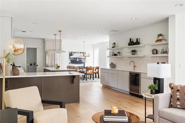 a kitchen with a sink stove and white cabinets with wooden floor