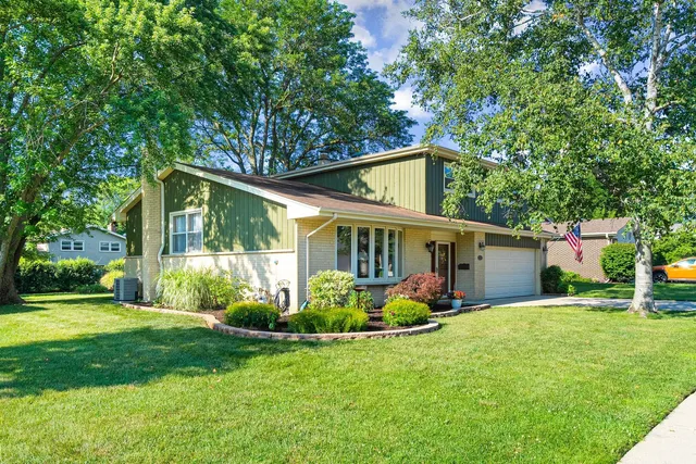 a view of a house with big yard and large trees