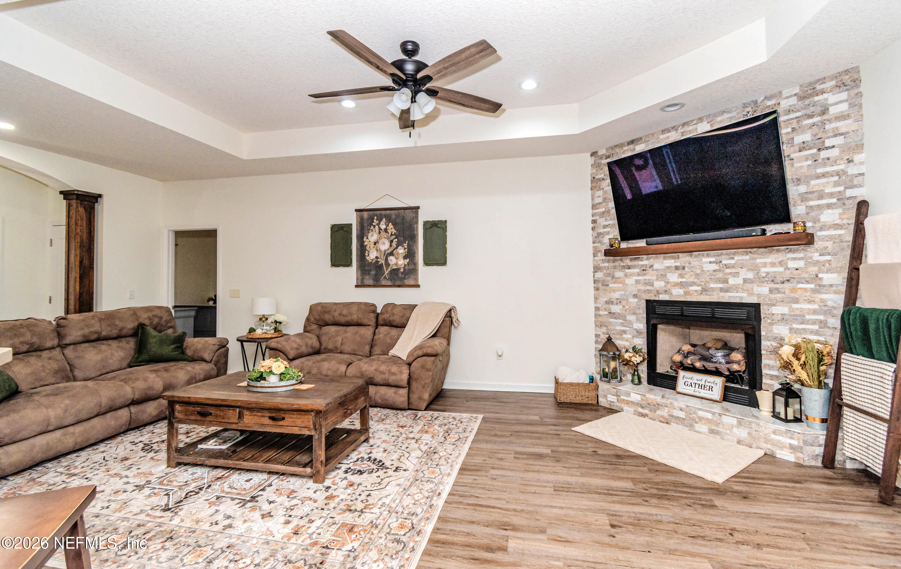 8139 Hunters Ridge South Glen St. Mary, FL 32040 - Photo 12 of 49 a living room with furniture a flat screen tv and a fireplace