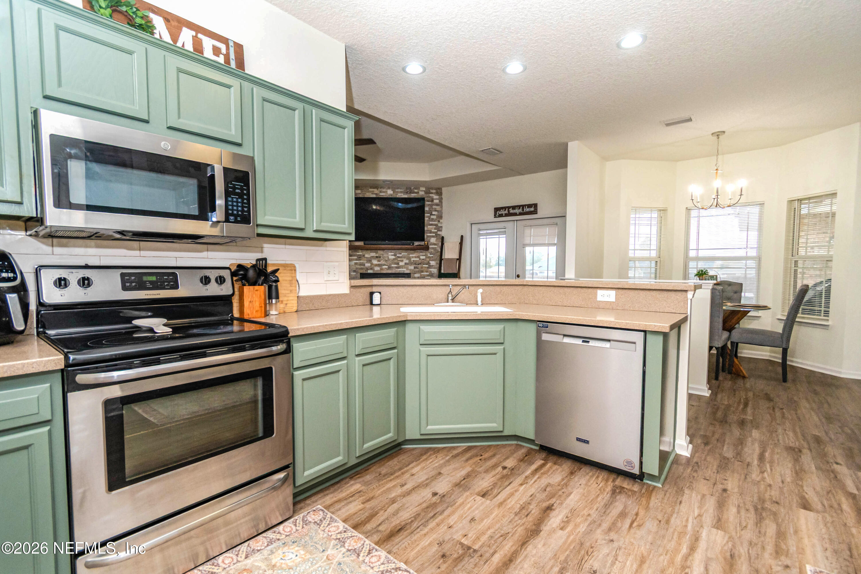 8139 Hunters Ridge South Glen St. Mary, FL 32040 - Photo 13 of 49 a kitchen with stainless steel appliances granite countertop a stove and a microwave