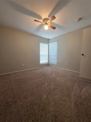 a view of a livingroom with a ceiling fan and window