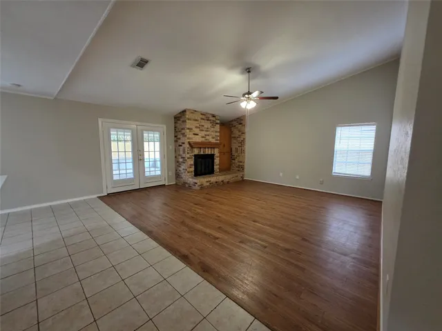 an empty room with windows and fireplace