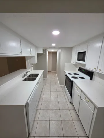 a kitchen with a sink a stove top oven and cabinets