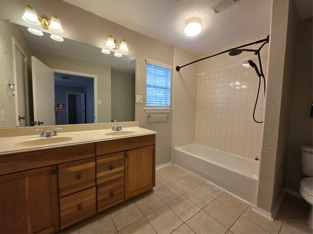 a bathroom with a tub a sink shower and mirror
