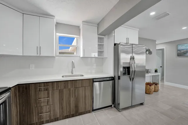 a kitchen with stainless steel appliances granite countertop a refrigerator and a sink