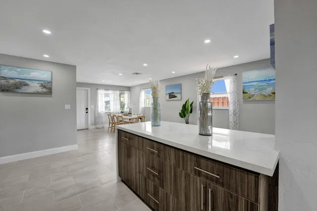 a large kitchen with kitchen island a sink stainless steel appliances and cabinets