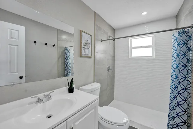 a bathroom with a sink toilet and shower