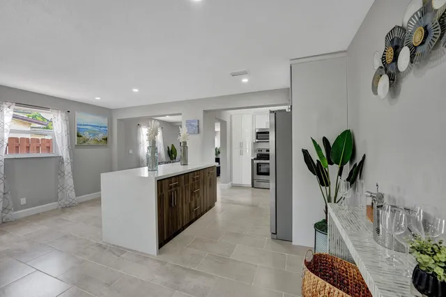 a kitchen with stainless steel appliances a counter top space cabinets and a potted plant