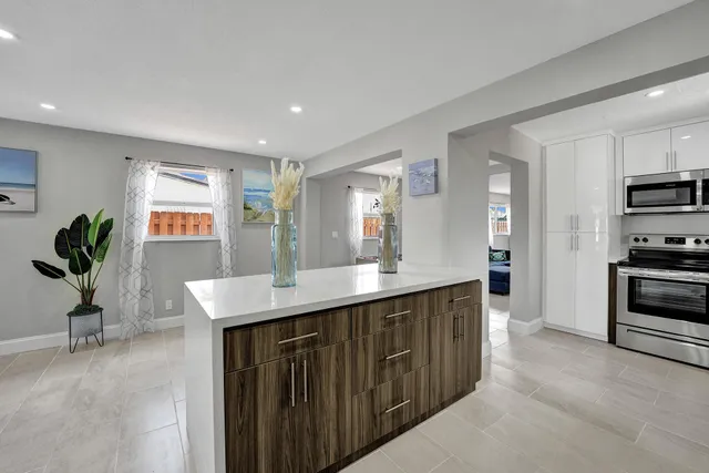 a kitchen with kitchen island a counter top space a sink and appliances