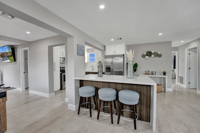 a dining hall with stainless steel appliances a table and chairs in it