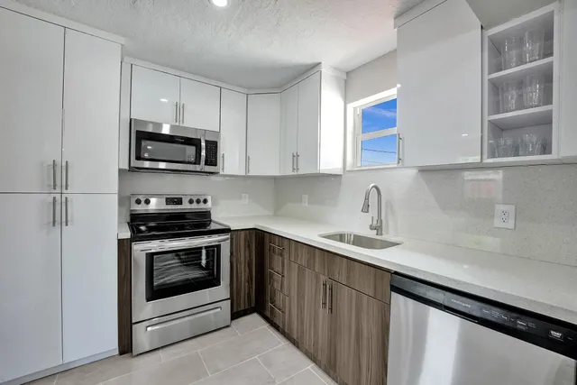 a kitchen with stainless steel appliances granite countertop a sink stove and microwave