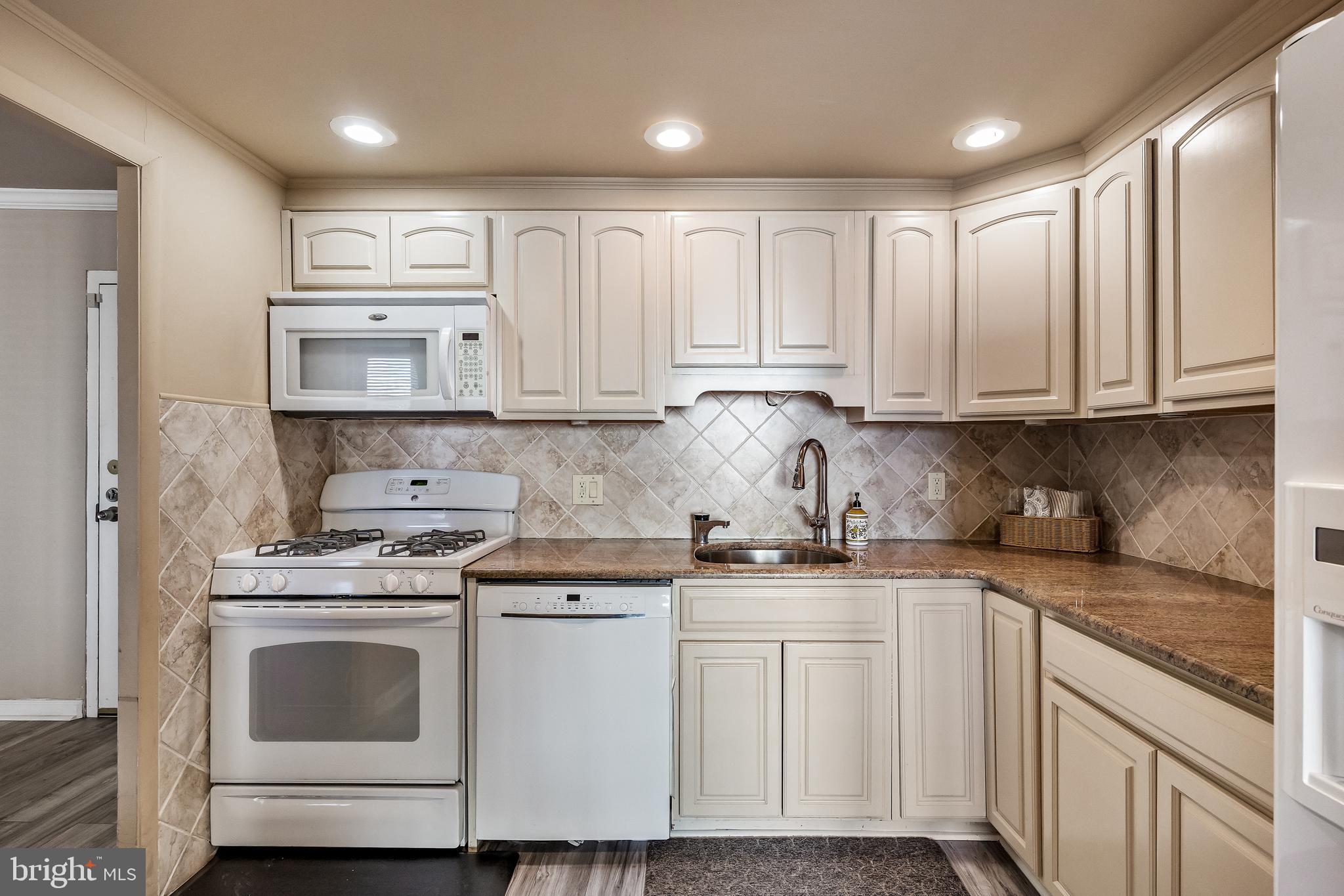 1840 Frontage Road, Unit 404 Cherry Hill, NJ 08034 - Photo 6 of 28 a kitchen with kitchen island white cabinets and white appliances