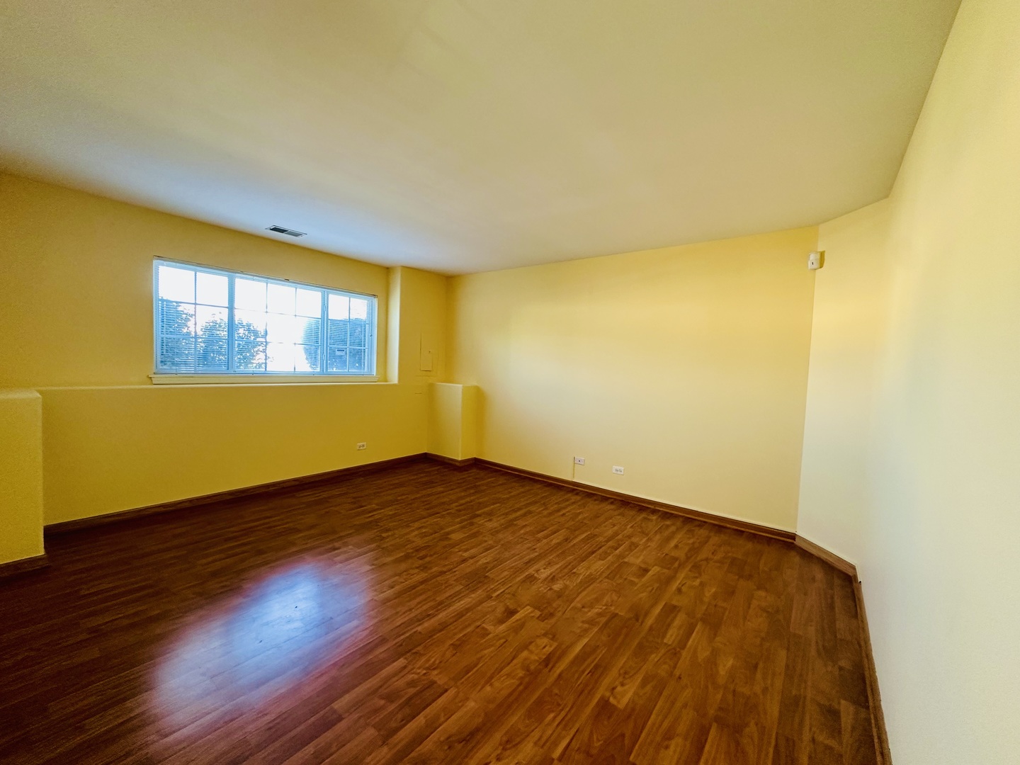 9499 Harrison Street, Unit 9499 Des Plaines, IL 60016 - Photo 11 of 17 a view of an empty room with wooden floor and a window