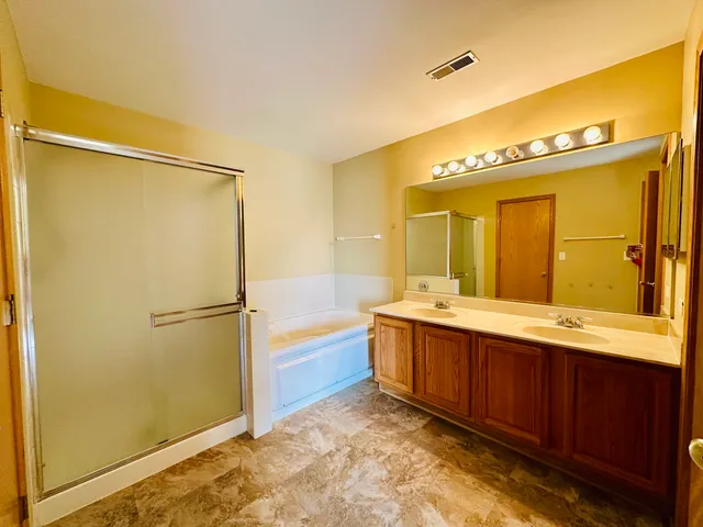 a bathroom with a tub sink and mirror