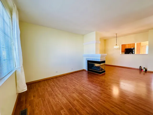 a view of a room with wooden floor and a window