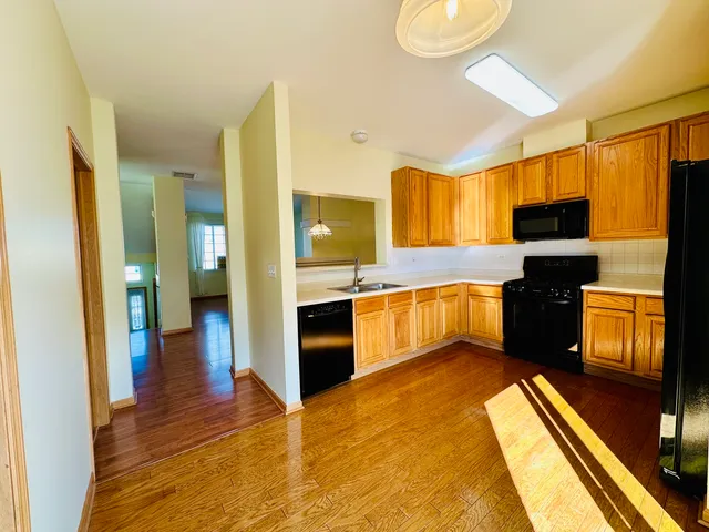a kitchen with stainless steel appliances granite countertop a refrigerator a stove and a sink