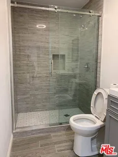 a view of a kitchen from the hallway with a wooden floor