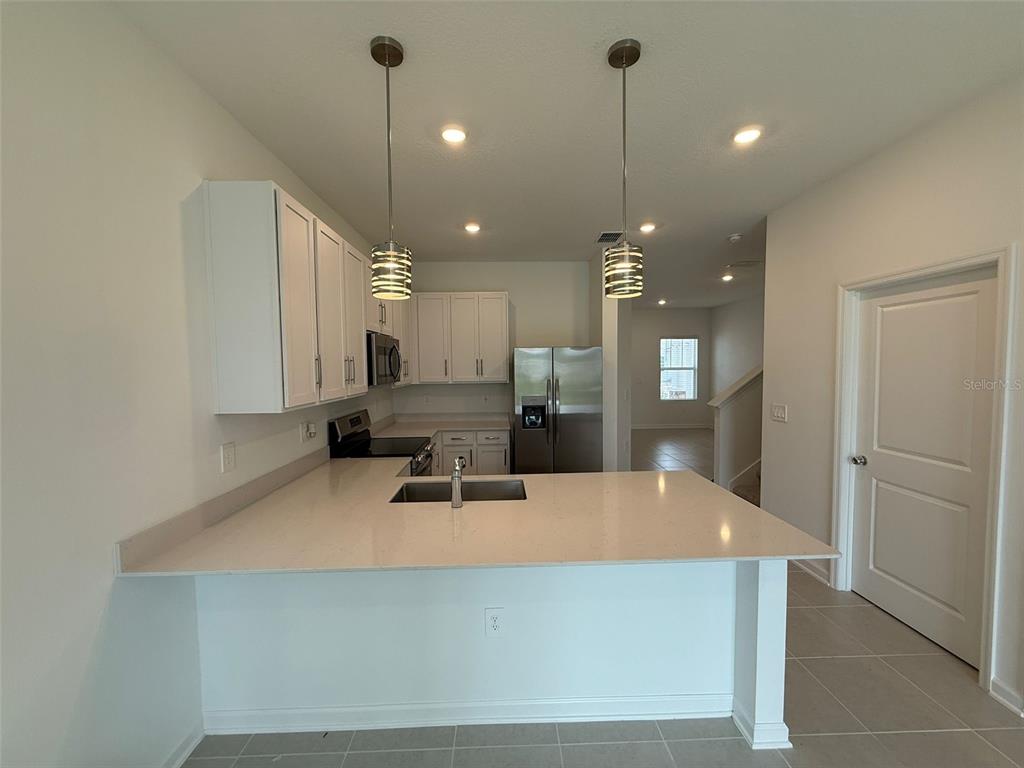 2691 Skyline Loop Kissimmee, FL 34758 - Photo 11 of 27 a room with kitchen island a sink wooden floor and white appliances
