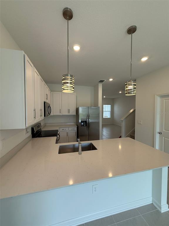 2691 Skyline Loop Kissimmee, FL 34758 - Photo 13 of 27 a large kitchen with stainless steel appliances a large counter top a refrigerator and a sink