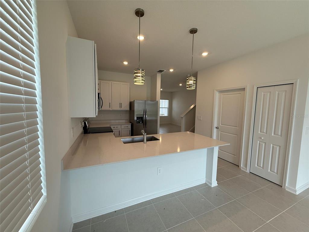 2691 Skyline Loop Kissimmee, FL 34758 - Photo 15 of 27 a large kitchen with kitchen island a sink a counter space and a refrigerator